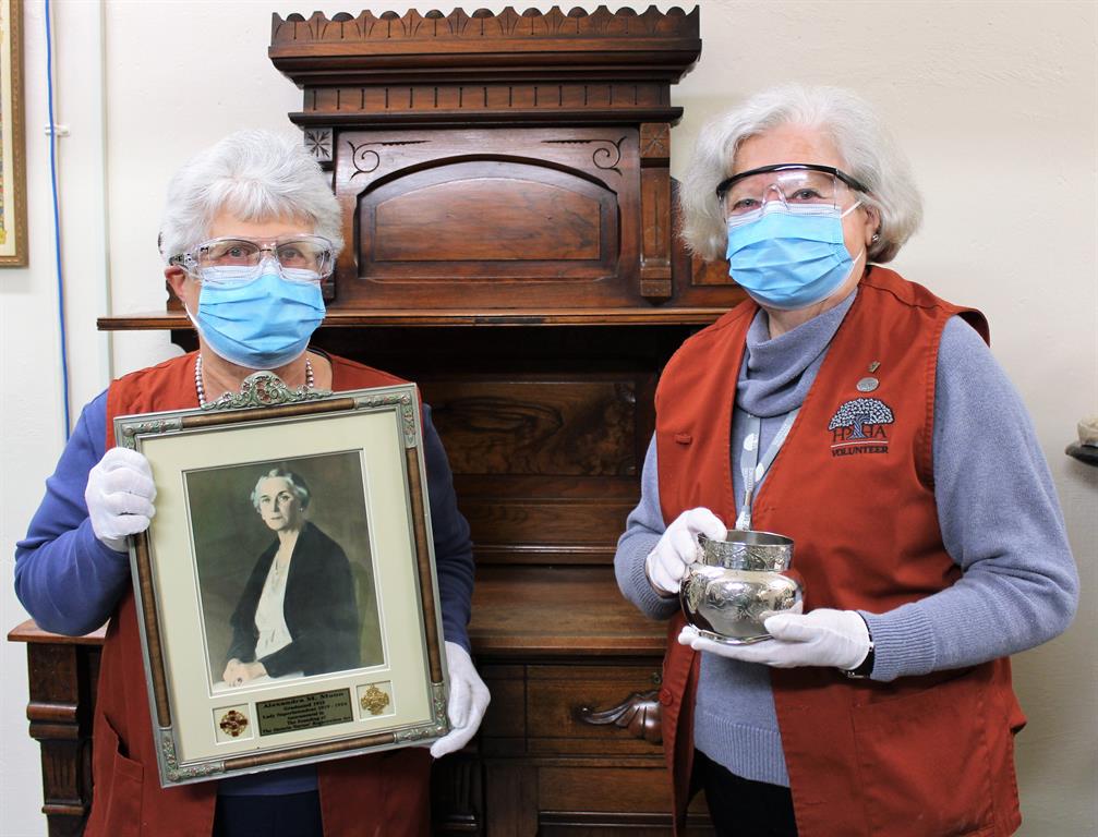Archive volunteers pose with items from the collection